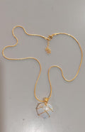 Gold necklace with a pendant on a gray background