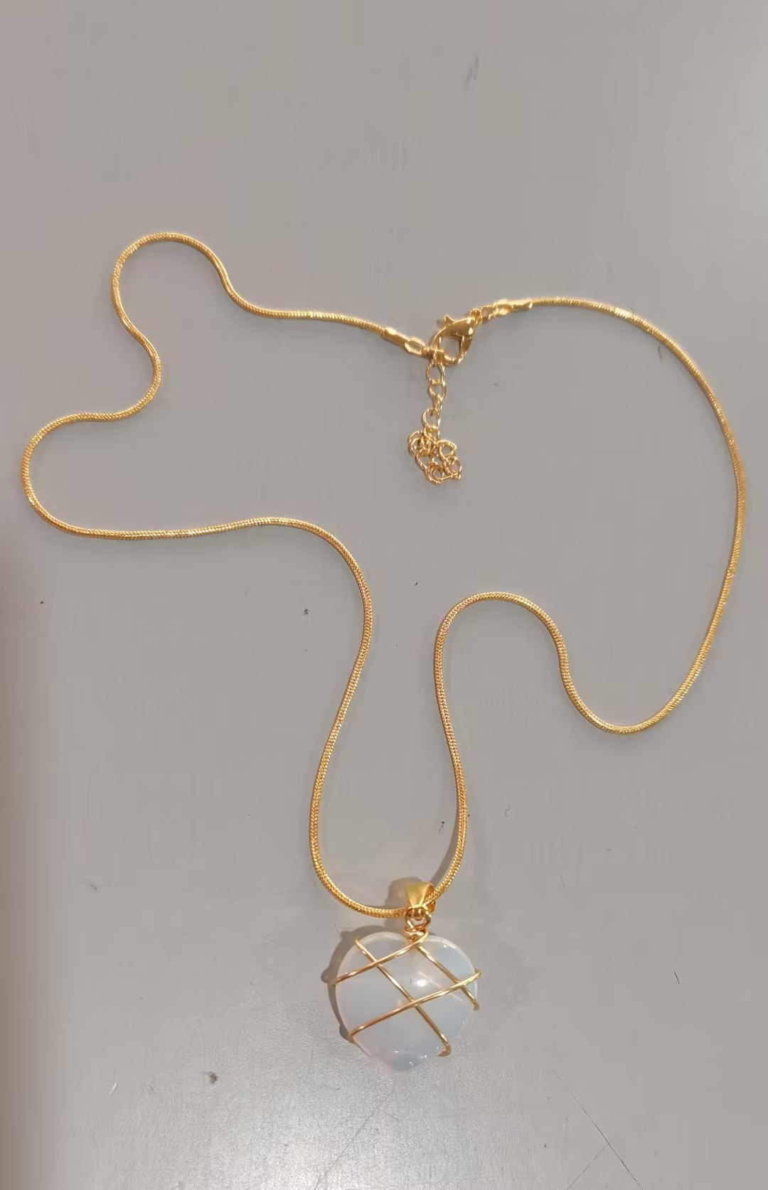 Gold necklace with a pendant on a gray background