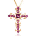 Gold cross necklace with pink gemstones on a white background