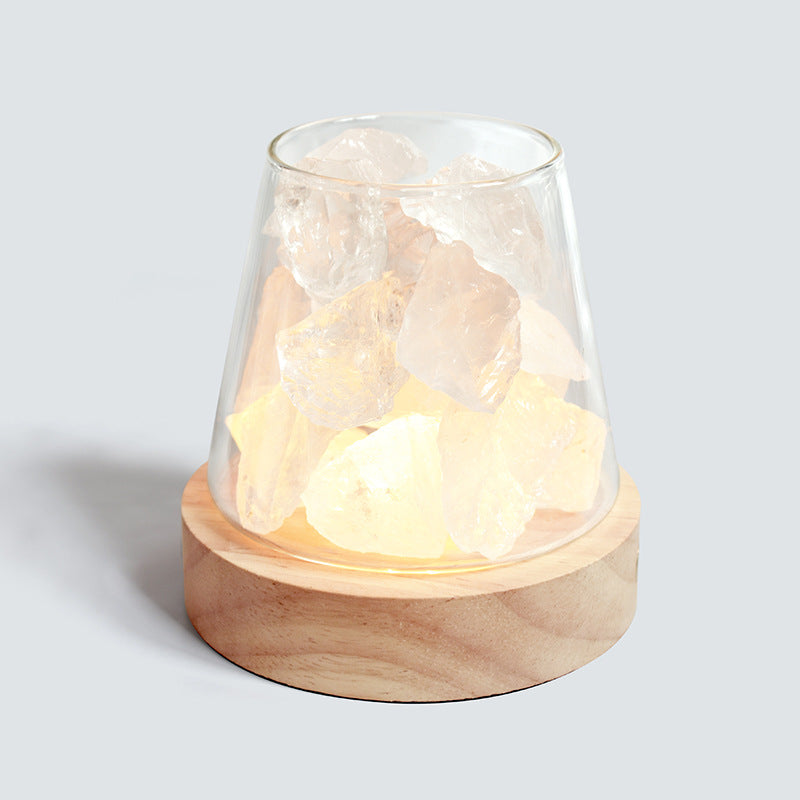 Decorative lamp with glass cover and wooden base on a light gray background