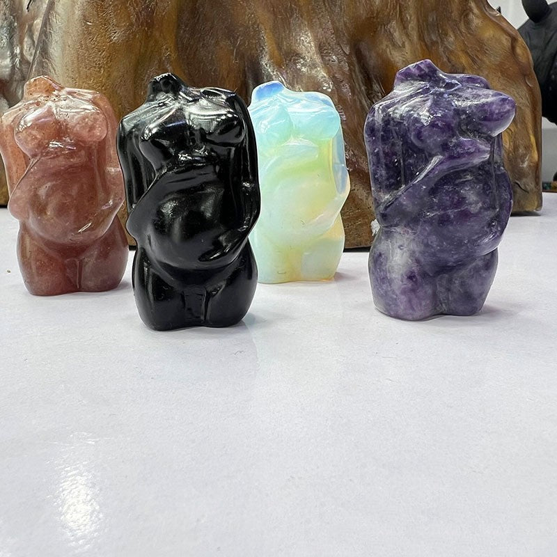 Four crystal bear figurines in different colors on a white surface with a wooden background.