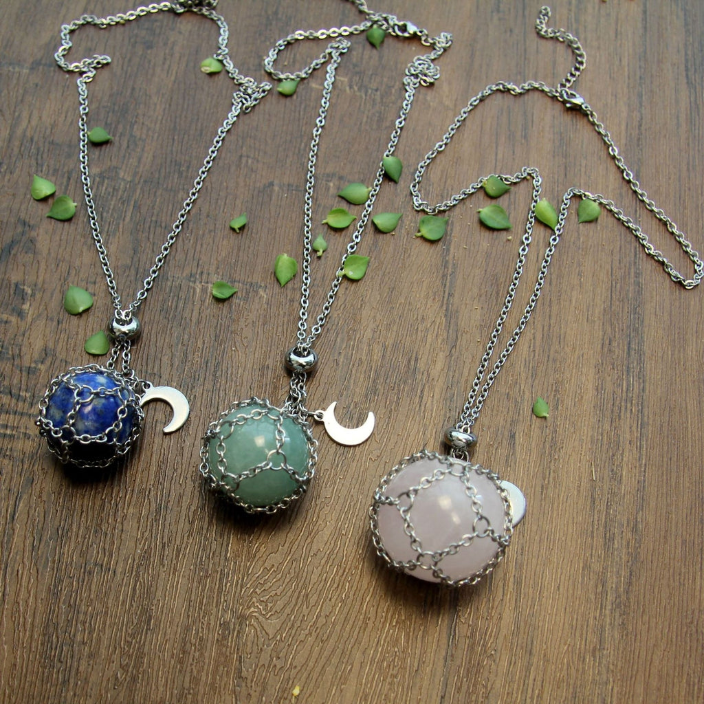 Three necklaces with round pendants on a wooden surface