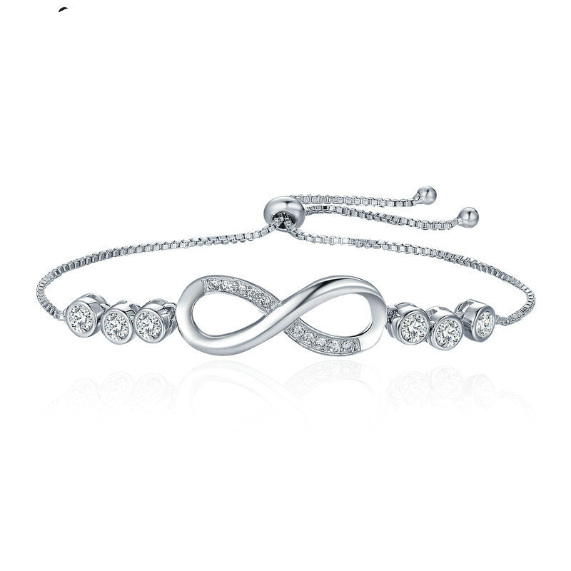 Silver bracelet with infinity design and clear stones on a white background