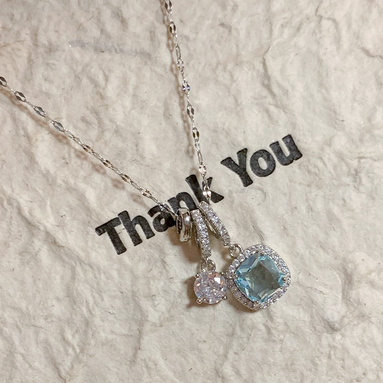 Necklace with gemstones on a textured surface with 'Thank You' text.