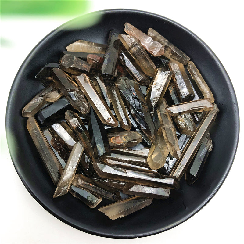 Black bowl filled with various crystal pieces on a white background