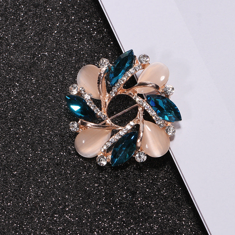 Decorative brooch with blue and beige stones on a black and white background
