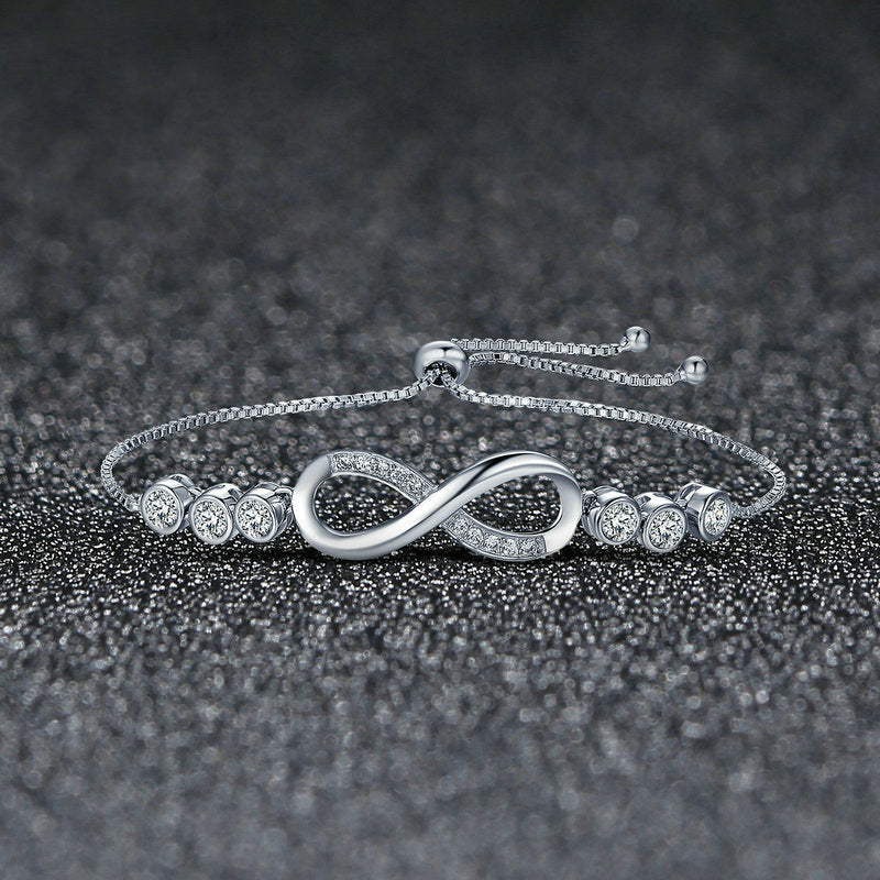 Silver bracelet with infinity design on a dark textured background
