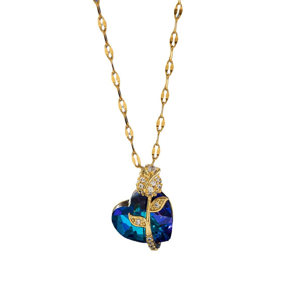 Gold necklace with a blue heart-shaped pendant on a white background