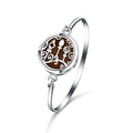 Silver bracelet with a circular design featuring a tree of life symbol on a white background
