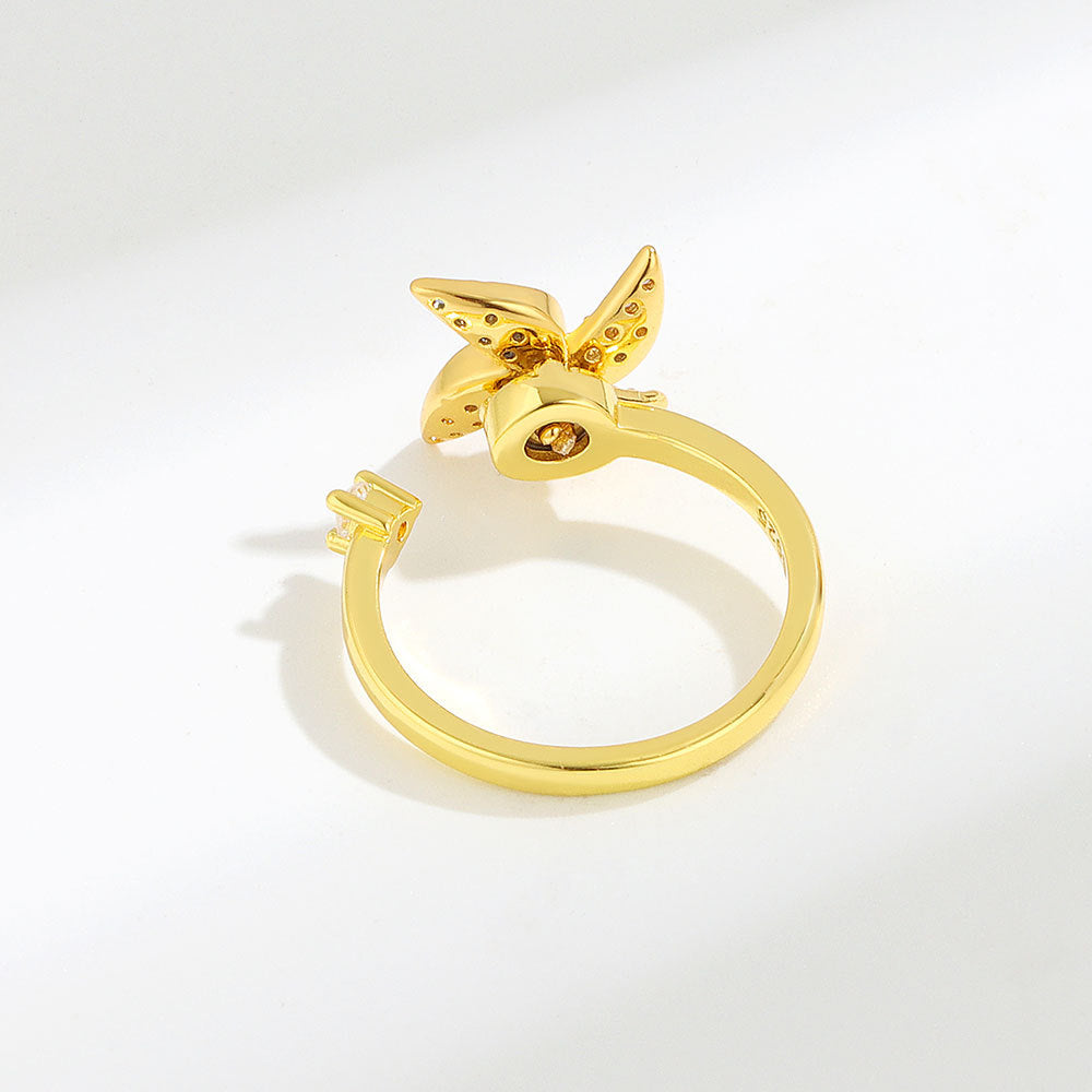 Gold ring with a butterfly design on a white background