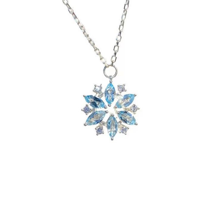 Snowflake-shaped pendant necklace with blue stones on a white background