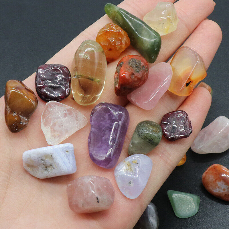 Hand holding a variety of colorful crystals on a dark background