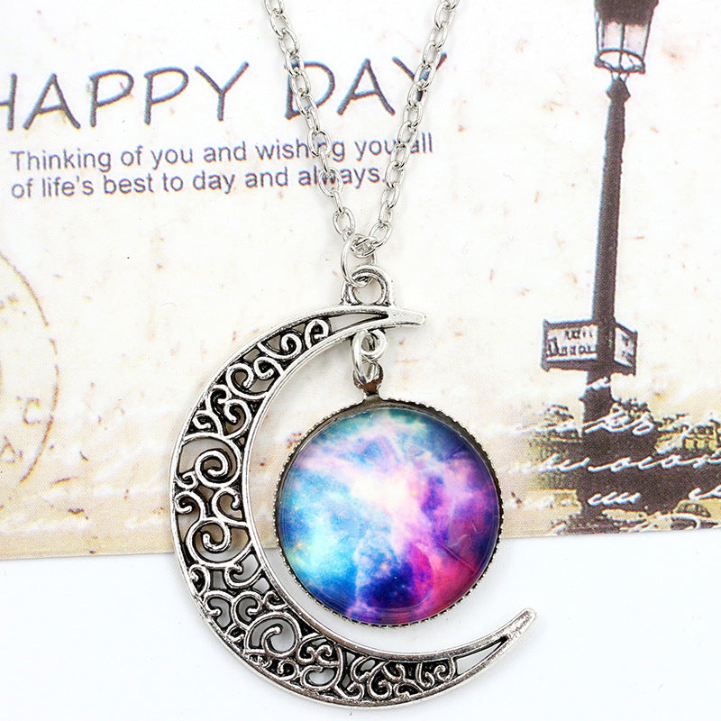 Necklace with a crescent moon pendant featuring a colorful galaxy design on a vintage card background.