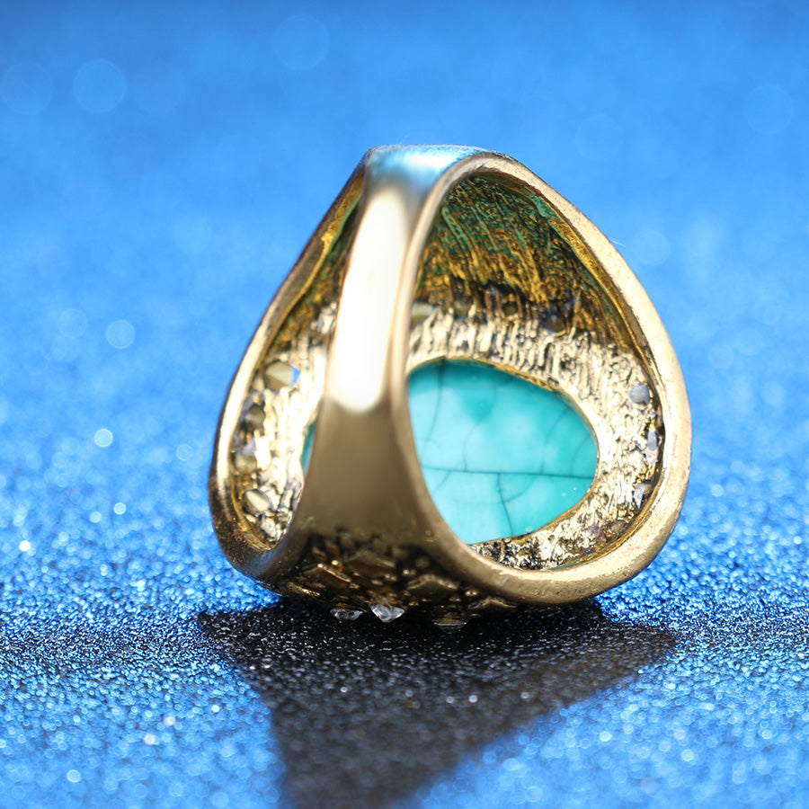 Gold ring with a turquoise stone on a blue background