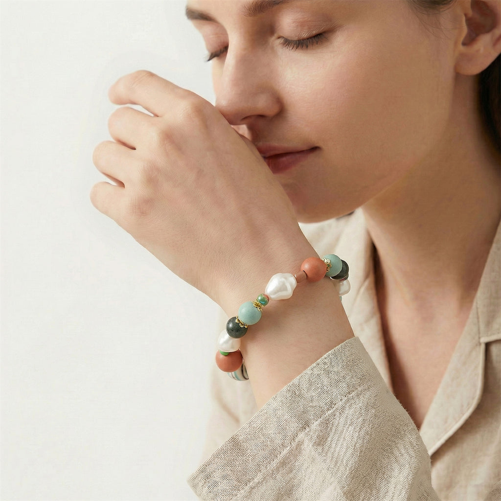 Woman wearing a colorful beaded bracelet on a plain background