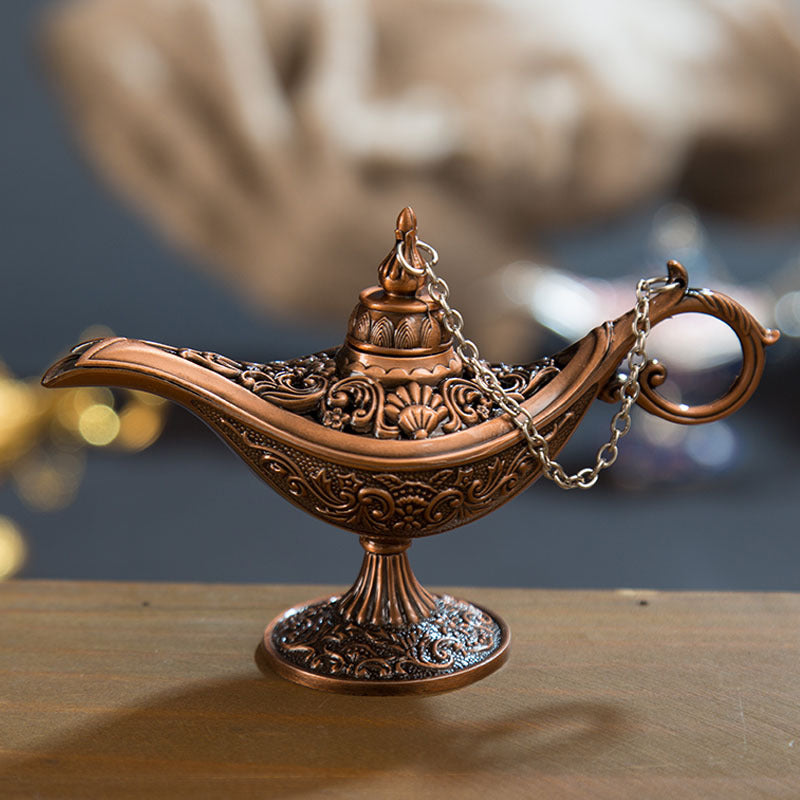 Decorative bronze lamp with intricate designs on a wooden surface.
