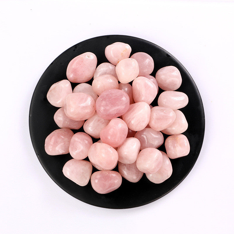 Pink stones on a black plate with a white background