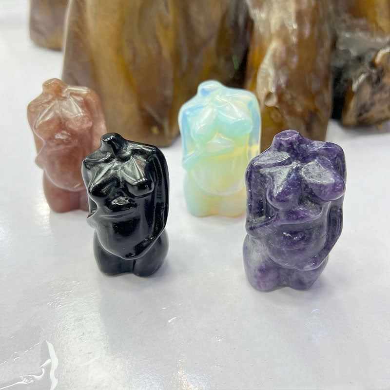 Colorful crystal animal figurines on a white surface with blurred stones in the background