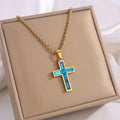 Gold necklace with a blue cross pendant on a beige display box.