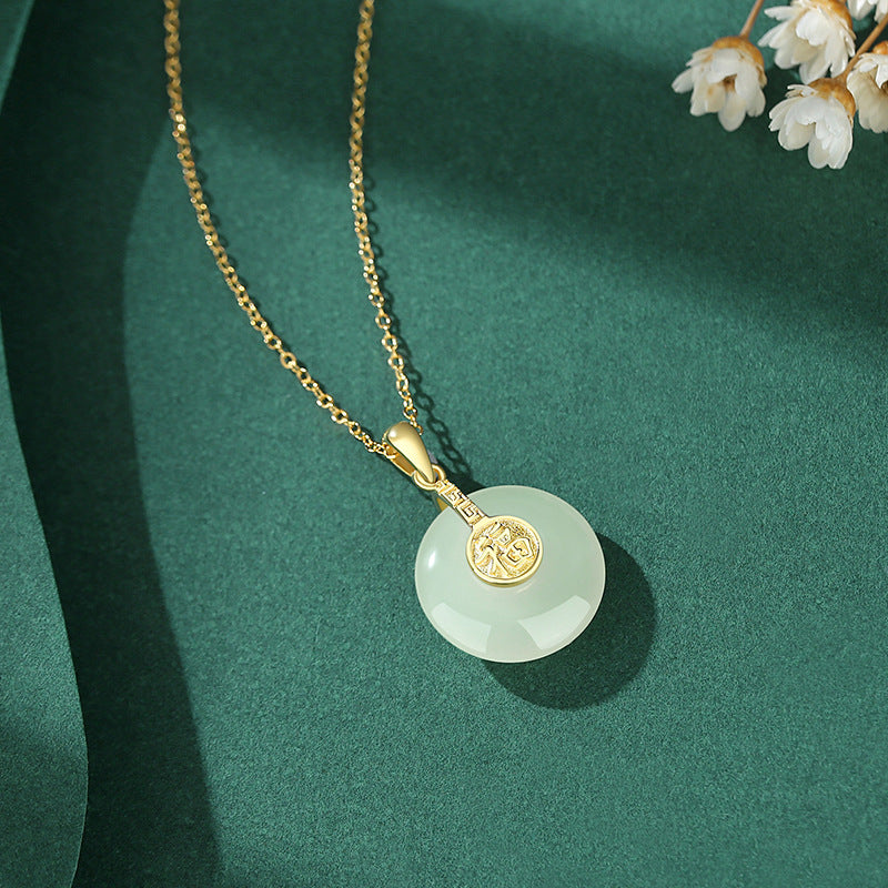 Gold necklace with a round green pendant on a green background