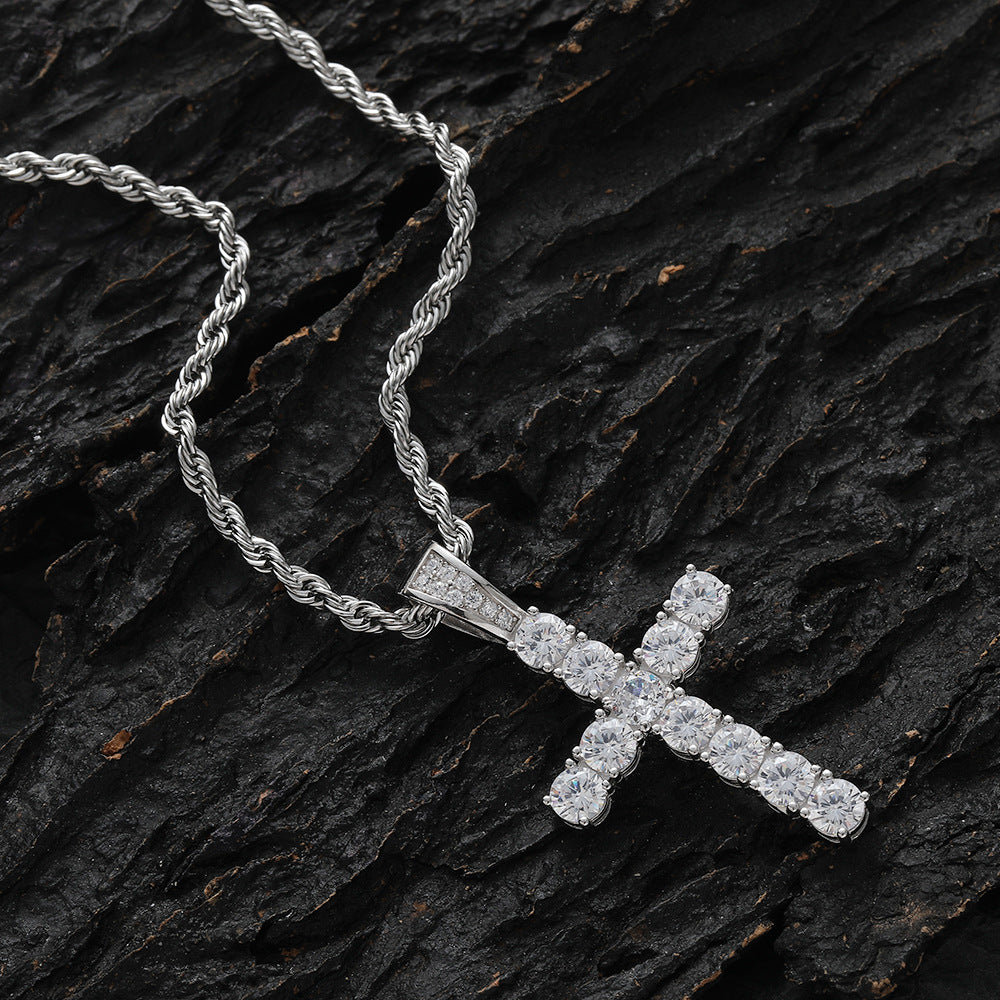 Silver cross pendant necklace on a dark wooden surface