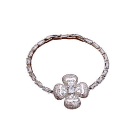 Silver bracelet with a clover-shaped clasp on a white background