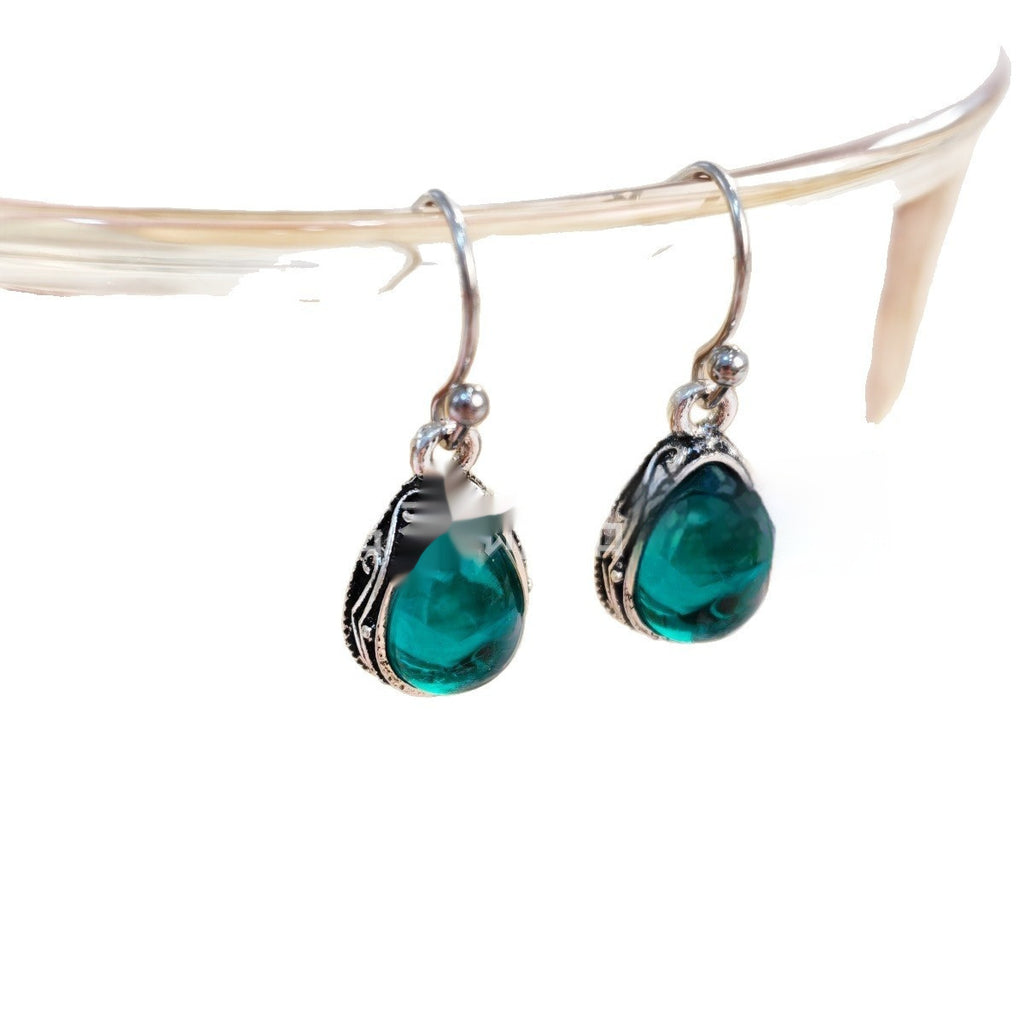Teardrop-shaped green earrings with silver hooks on a white background