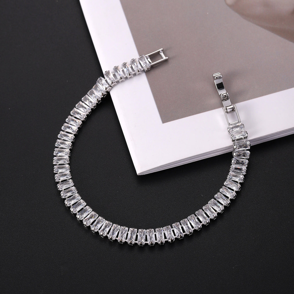 Silver bracelet with clear stones on a black surface