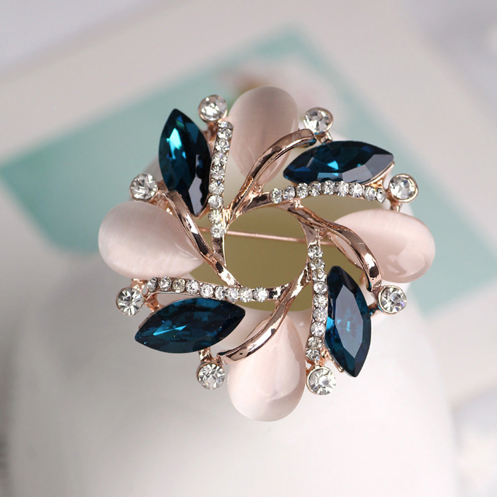 Decorative brooch with blue gemstones and pink stones on a blurred background