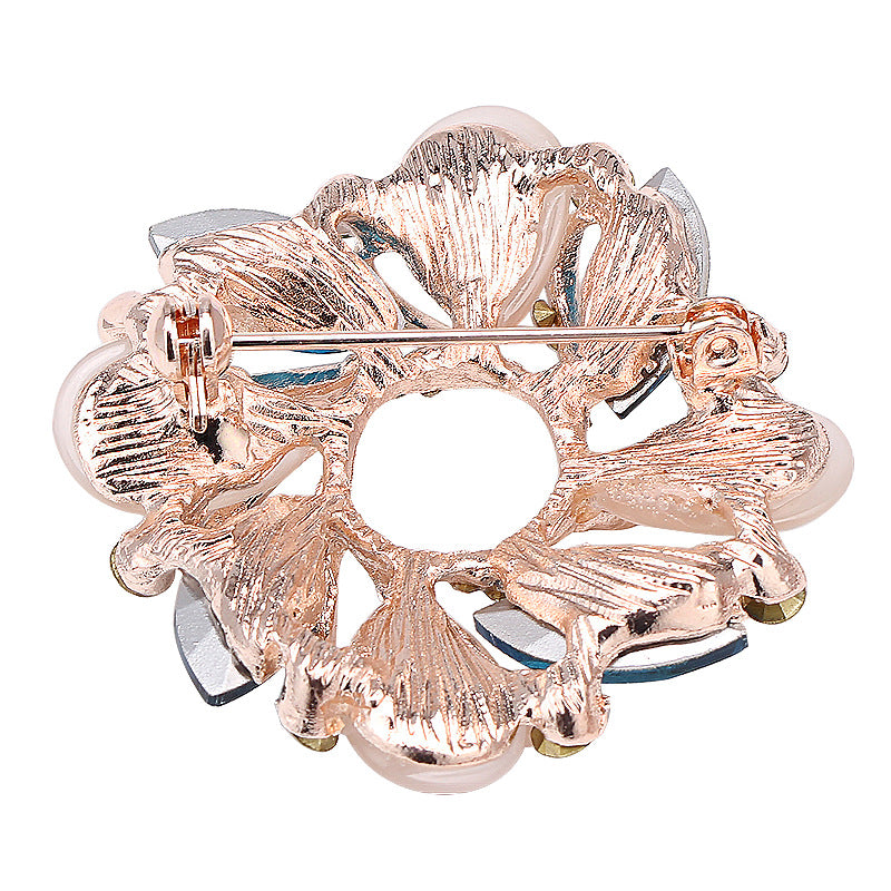 Rose gold floral brooch on a white background