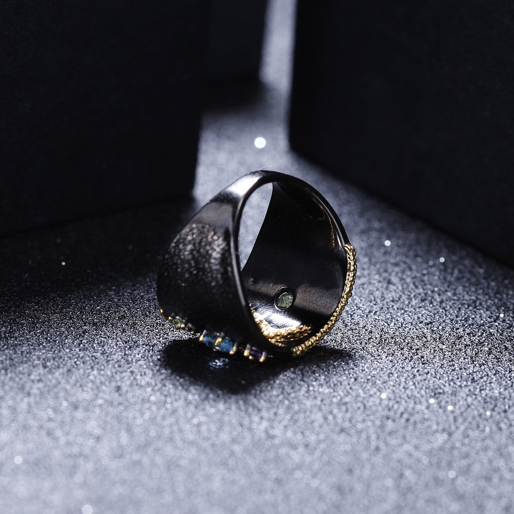 Ring with a reflective surface on a textured gray surface