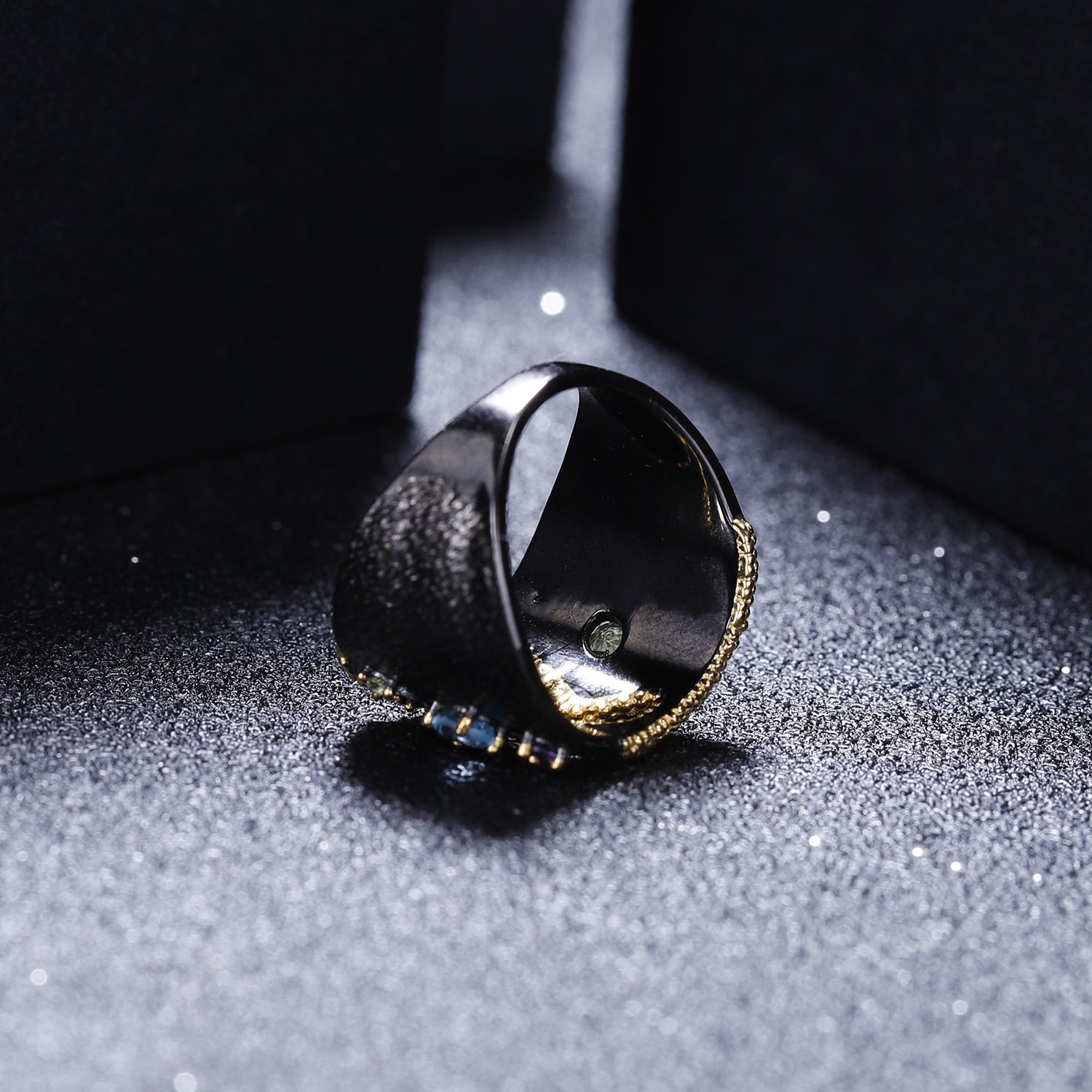 Ring with a reflective surface on a textured gray surface