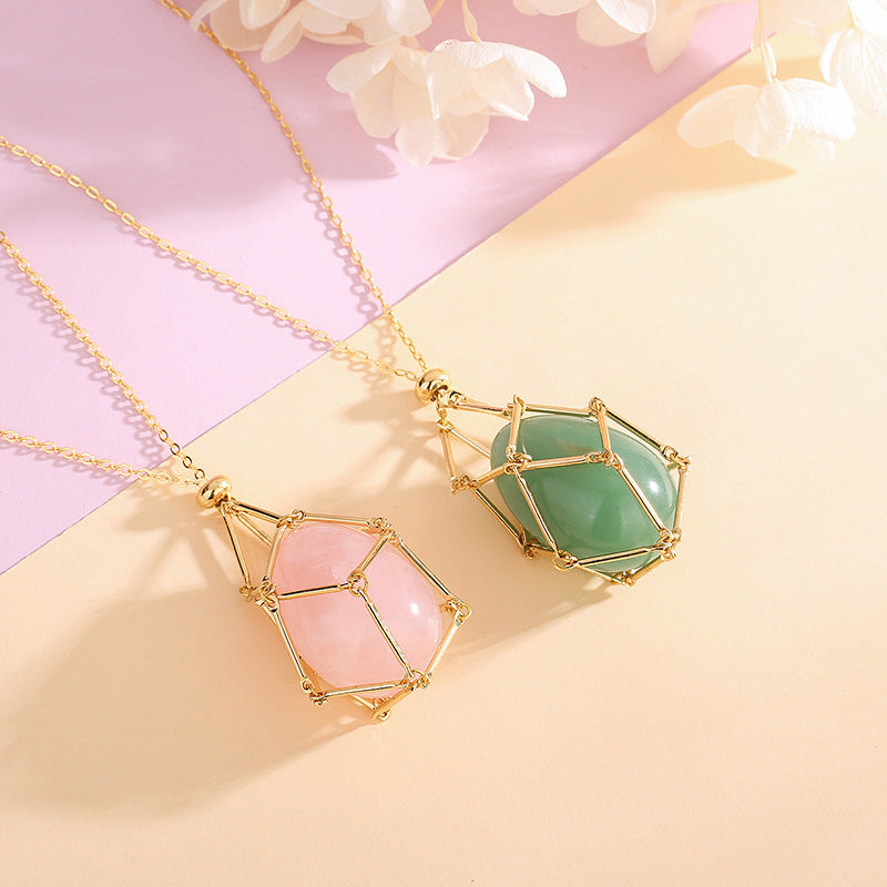 Two geometric pendants on gold chains with a soft pink and yellow background.
