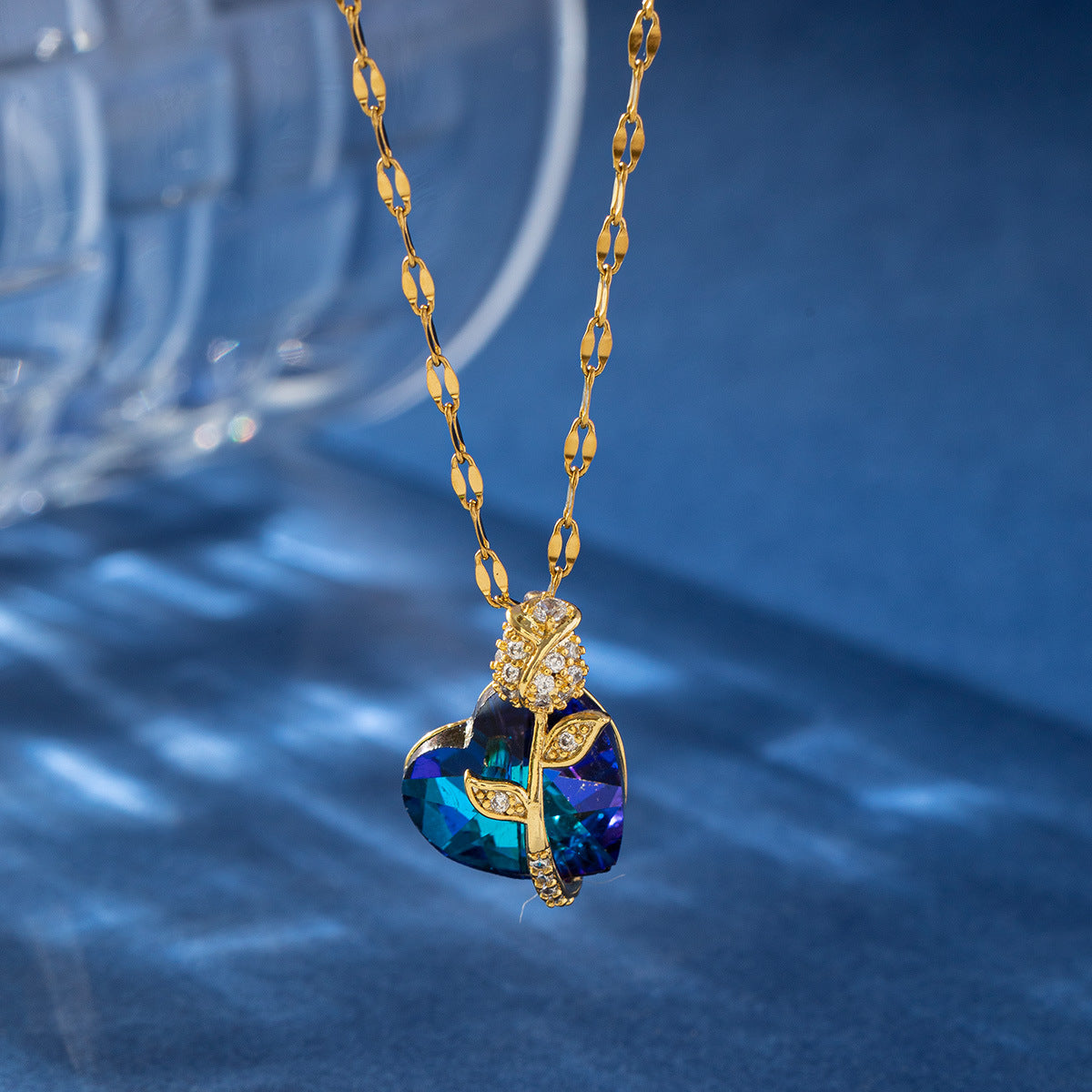 Gold necklace with a blue pendant on a blue background