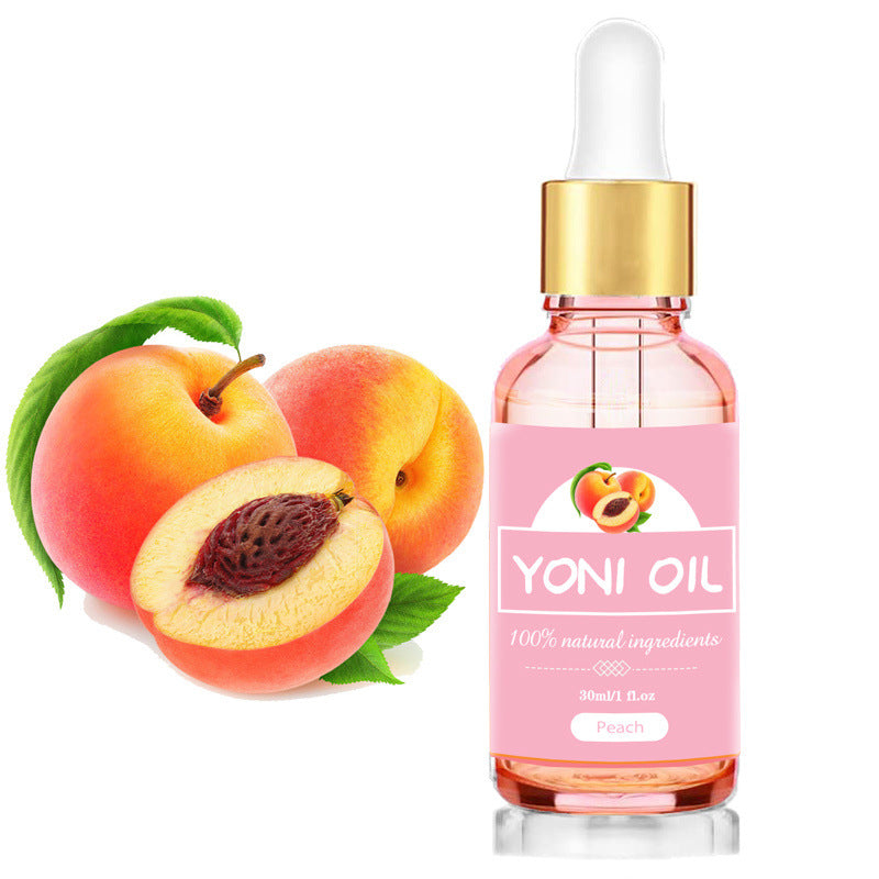 Yoni Oil bottle with peach and half peach on a white background