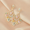 Elegant earrings with multicolored gemstones on a beige fabric background