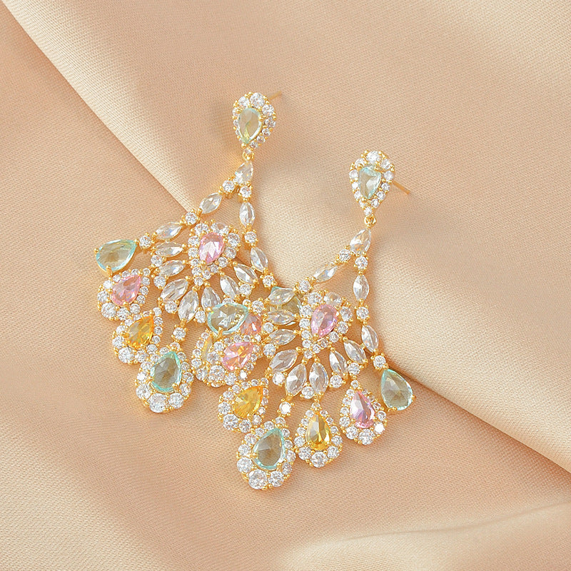 Elegant earrings with multicolored gemstones on a beige fabric background