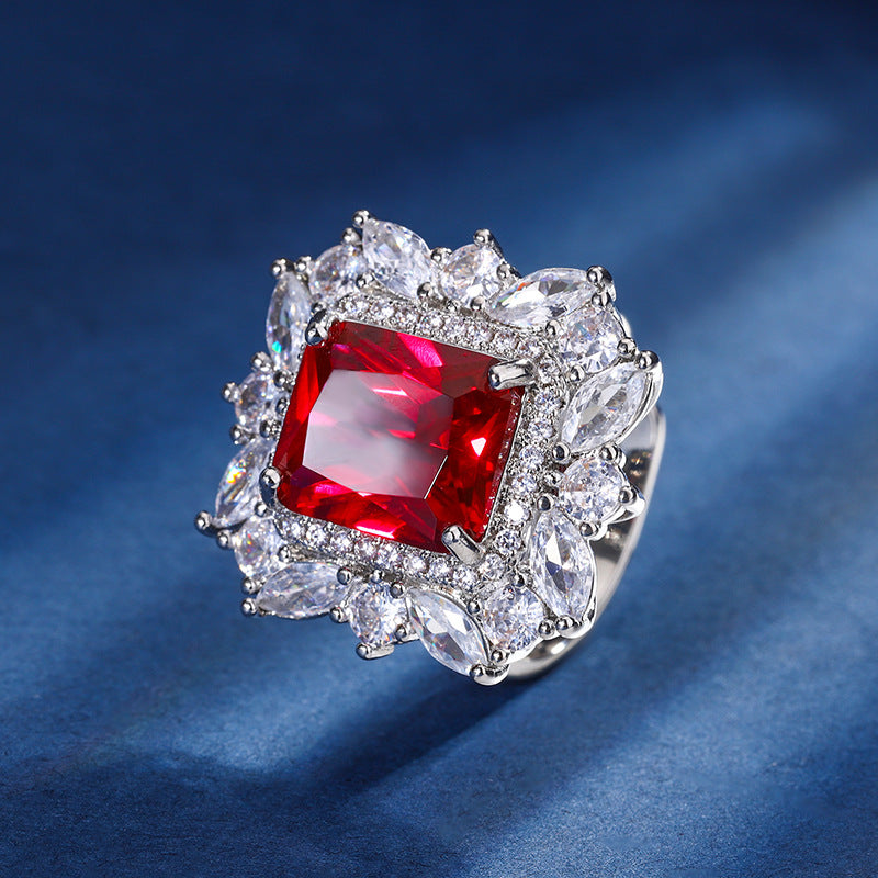 Ring with a red gemstone and diamond-like stones on a blue background