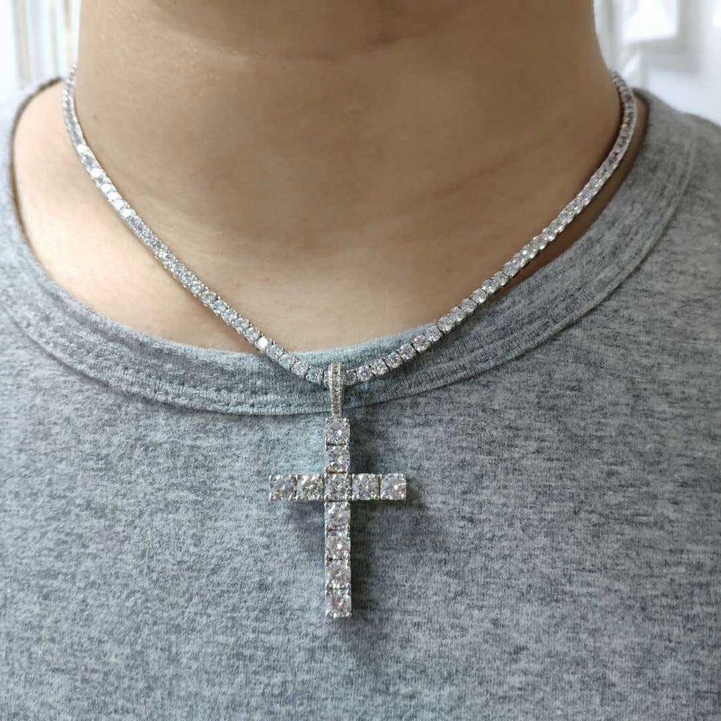 Necklace with a cross pendant worn by a person in a gray shirt