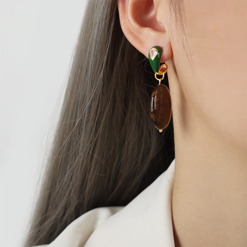 Close-up of a person wearing a colorful earring with a neutral background