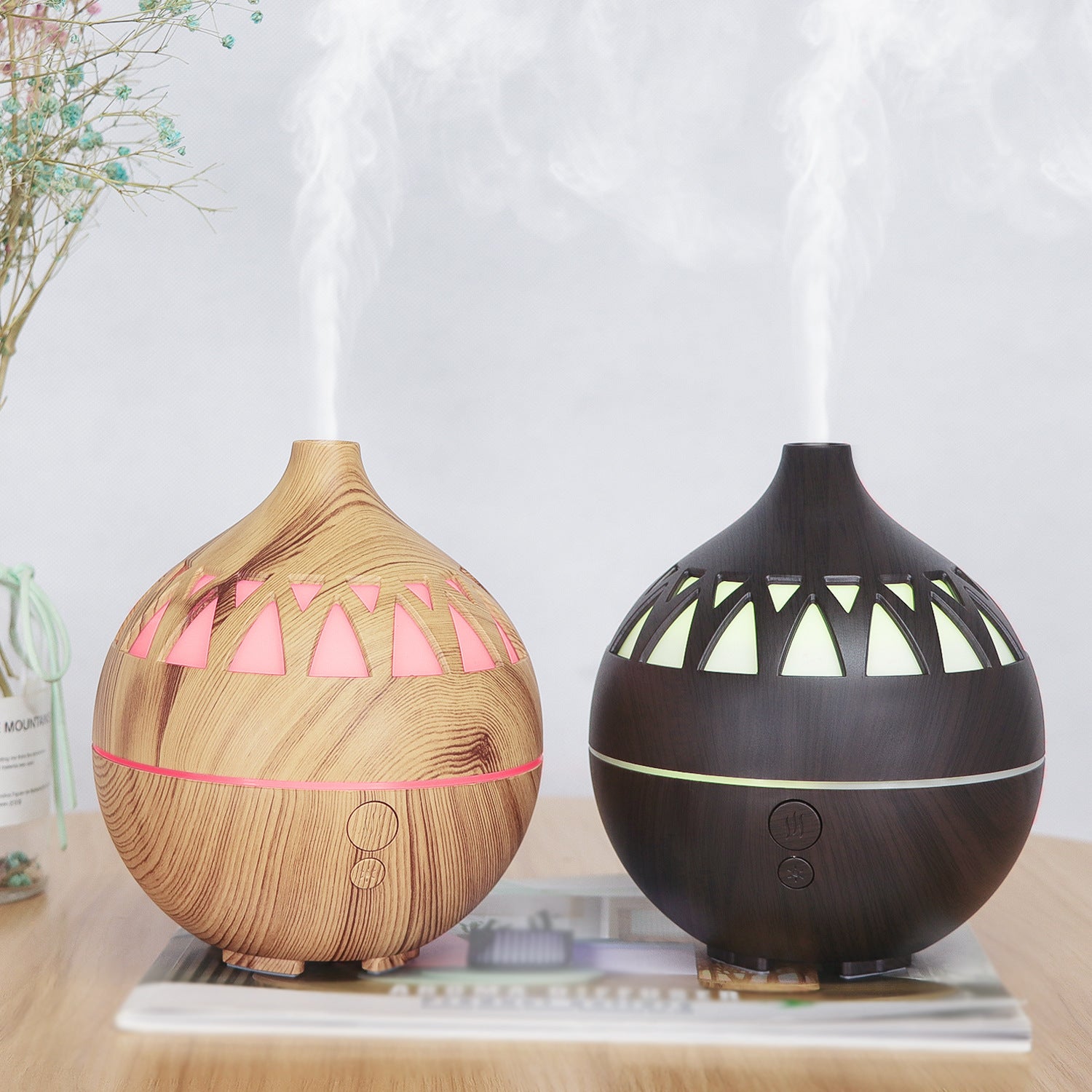 Two diffusers, one wooden and one black with geometric patterns, on a table.