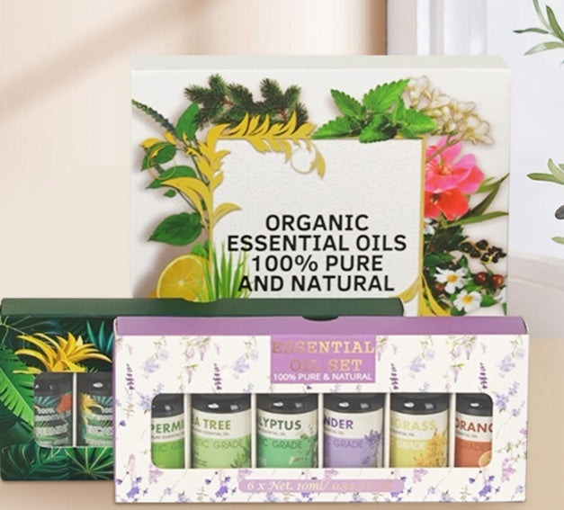 Set of organic essential oils with a decorative box featuring plants and flowers.