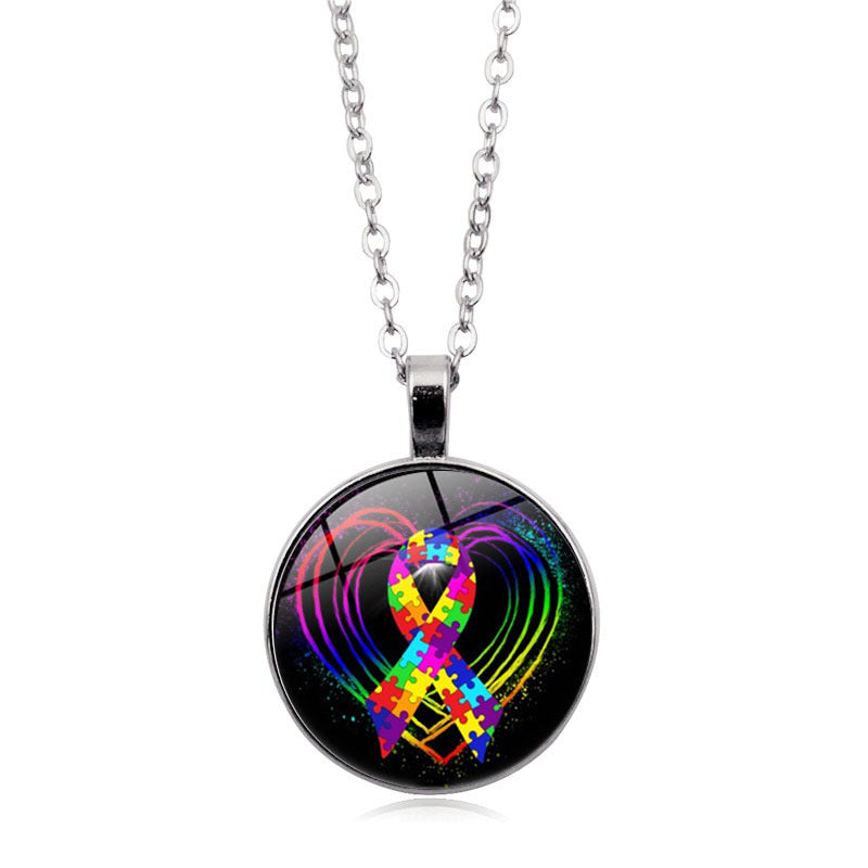 Necklace with a colorful autism awareness ribbon pendant on a black background