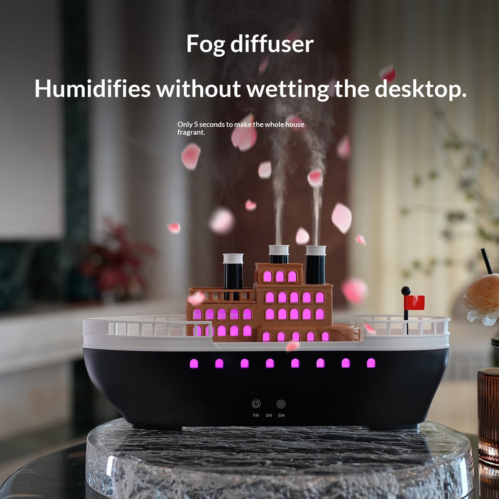 Fog diffuser with building model on a desk, emitting mist.