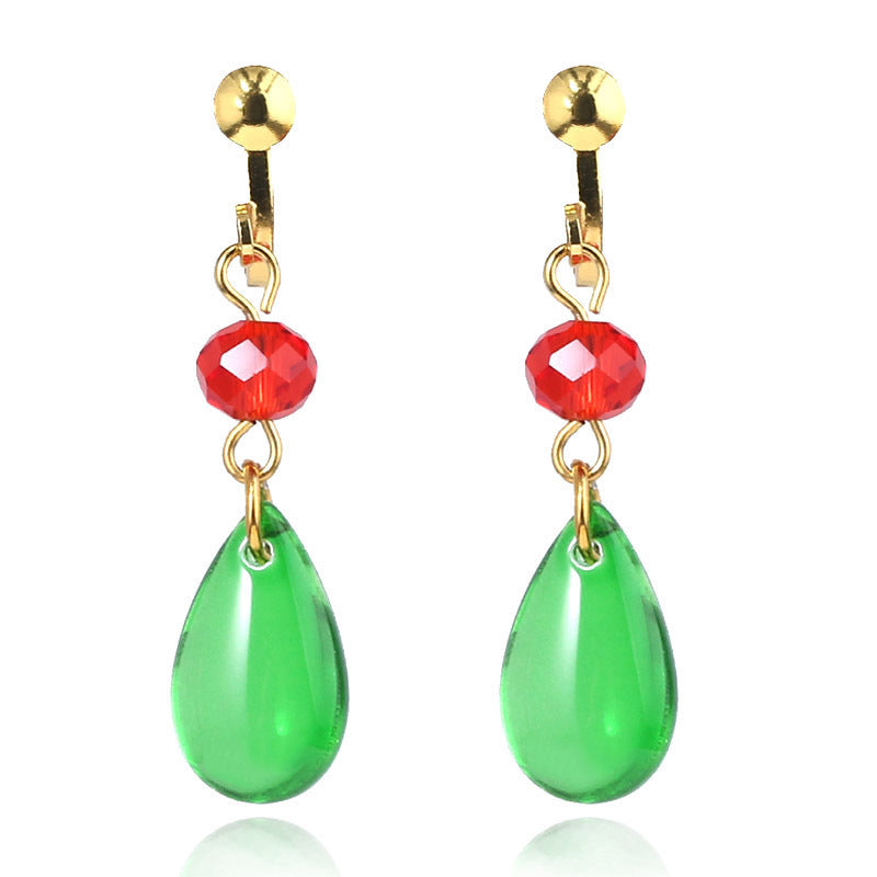 Pair of earrings with green teardrop stones and red beads on a white background