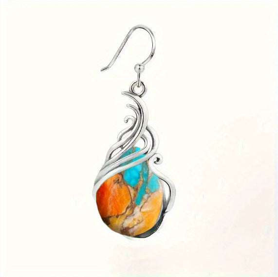 Silver earring with a colorful stone on a white background