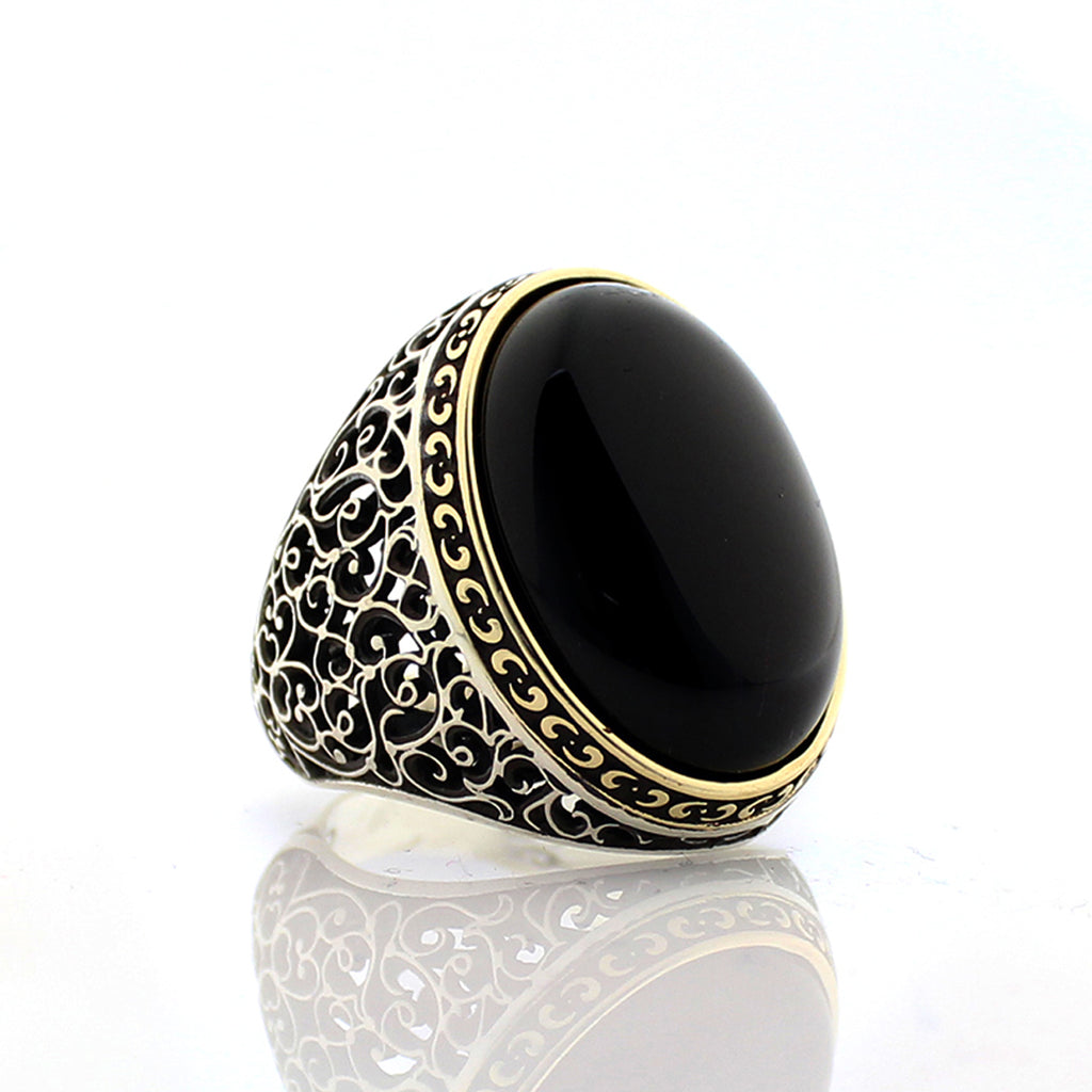 Black ring with gold decorative band on a white background