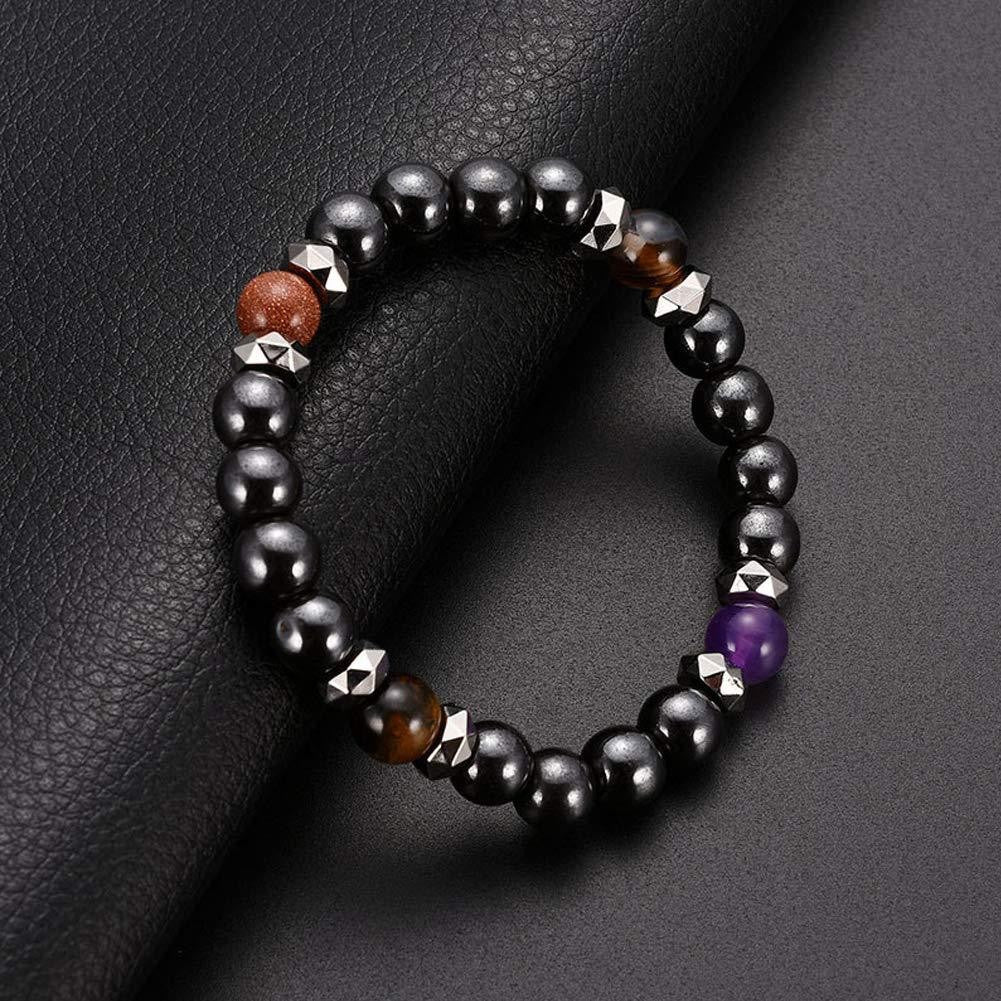 Black beaded bracelet with metallic accents and a purple bead on a dark textured surface