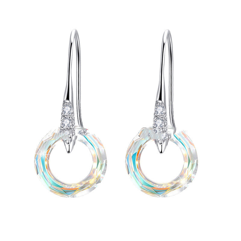 Pair of silver earrings with circular designs on a white background