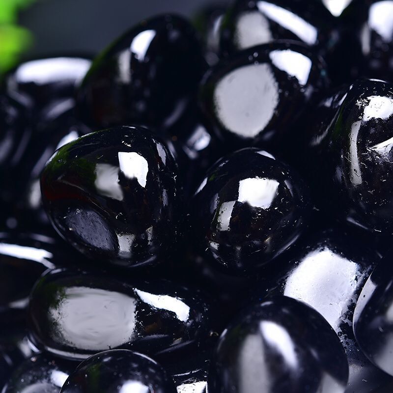 Close-up of glossy black stones with a blurred background